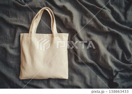 Professional Mockup of Simple White Tote Bag on Dark Fabric Background 138663433