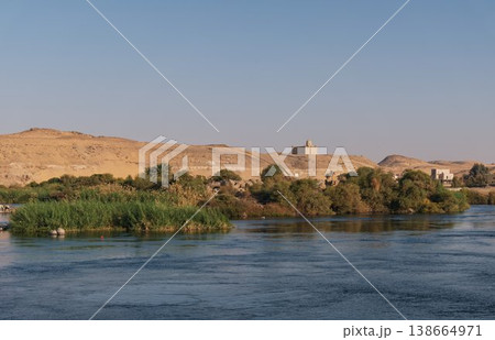 アスワンのナイル川と砂丘の風景、対岸に佇む小さなモスクと緑洲 アスワンのナイル川と砂丘の風景、対岸に佇む小さなモスクと緑洲 138664971