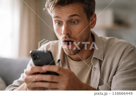 Excited Remote Worker. Young Freelancer Reacts To Unexpected Career Update. Casual Remote Professional Displays Amazement Upon Hearing Exciting Employment News At Residence 138666449