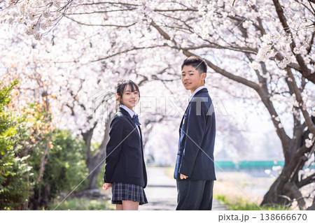 桜の下で振り返る制服を着たふたりの生徒 138666670