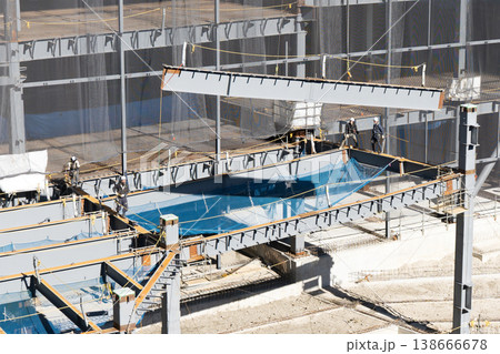 鉄骨建設現場でクレーンにより鉄骨梁を揚重する建方作業の様子6 138666678