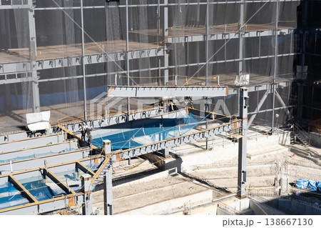 鉄骨建設現場で吊り荷をロープで誘導する作業員とクレーン揚重作業の様子4 138667130