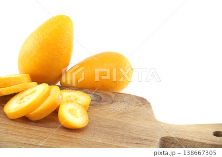 Fresh Kumquats On Wooden Cutting Board With Sliced Citrus Fruit On White Background Fresh Kumquats On Wooden Cutting Board With Sliced Citrus Fruit On White Background 138667305