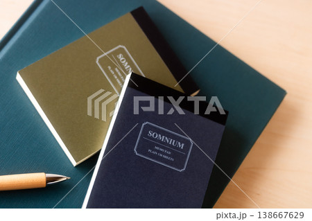 本の上のメモ帳とボールペン 138667629