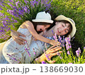 Mom and daughter in white dresses are lying in a lavender field. 138669030
