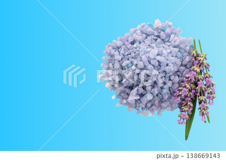 Lavender salt sits next to lavender flowers on a blue surface Lavender salt sits next to lavender flowers on a blue surface 138669143