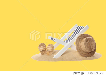 Chair with striped fabric and straw hat sits on sand Chair with striped fabric and straw hat sits on sand 138669172