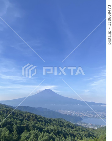 広い青空の下に深緑の山すその林と水を湛えた河口湖、その先に末広がりの秀麗な初夏の真っ青な富士山 138669473