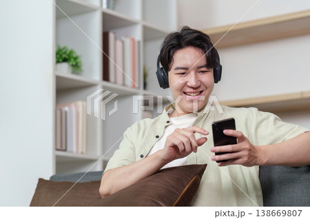 Young man enjoying smartphone entertainment with headphones Young man enjoying smartphone entertainment with headphones 138669807