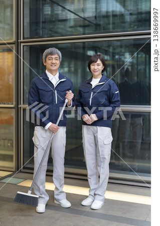 カメラ目線で笑顔のマンション管理スタッフの男女 全身 カメラ目線で笑顔のマンション管理スタッフの男女 全身 138669997