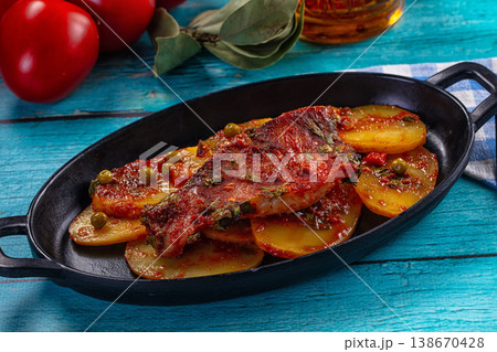 Baked fish fillet with tomato sauce and vegetables on a rustic blue wooden table Baked fish fillet with tomato sauce and vegetables on a rustic blue wooden table 138670428