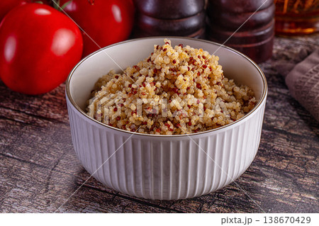 Healthy cooked tri-color quinoa in a bowl with fresh tomatoes and rosemary on a rustic wooden table Healthy cooked tri-color quinoa in a bowl with fresh tomatoes and rosemary on a rustic wooden table 138670429