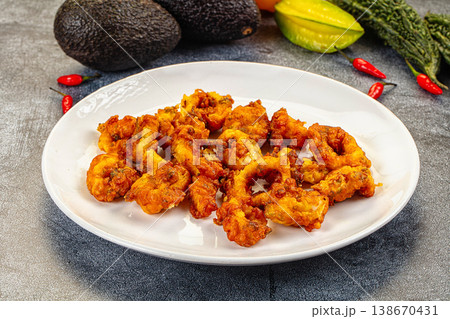 Crispy fried calamari rings appetizer on a plate with fresh chili and avocado. Crispy fried calamari rings appetizer on a plate with fresh chili and avocado. 138670431