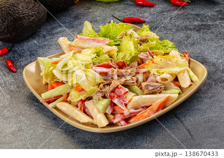 Hearty pasta salad with tuna and fresh vegetables on a dark, textured surface 138670433