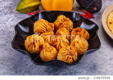 Golden fried dumplings momo in a skillet with fresh vegetables and flatbread Golden fried dumplings momo in a skillet with fresh vegetables and flatbread 138670500