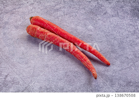 Two raw red carrots on a rustic wooden table. Fresh organic root vegetables. 138670508