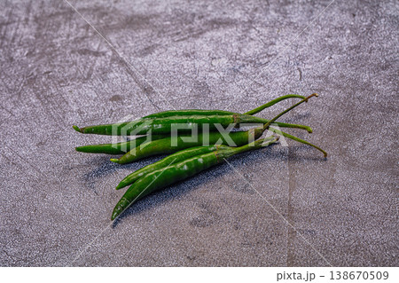 Fresh spicy green chili peppers on a rustic wood tabletop. Fresh spicy green chili peppers on a rustic wood tabletop. 138670509