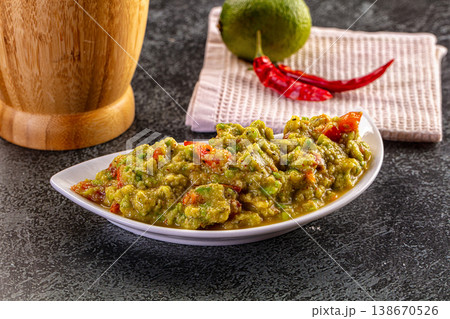 Freshly Made Guacamole with Avocado, Chili, and Lime on a Dark Table 138670526