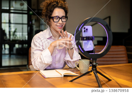Smiling female host talking during live broadcast recording 138670958