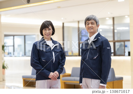 カメラ目線で笑顔の作業服を着た60代の男女 マンション管理人・施設スタッフ イメージ カメラ目線で笑顔の作業服を着た60代の男女 マンション管理人・施設スタッフ イメージ 138671017