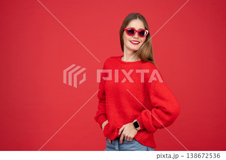 Smiling woman wearing sweater and sunglasses standing with hands in pockets 138672536