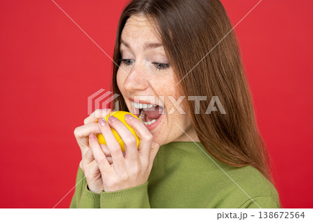 Woman biting sour lemon with funny facial expression 138672564