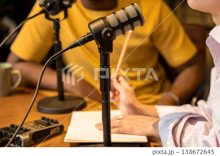Woman holding pencil and talking during podcast recording 138672645