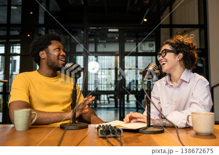 Diverse podcasters laughing during audio content creation Diverse podcasters laughing during audio content creation 138672675