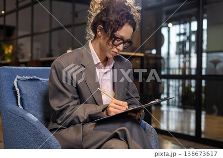Woman writing on clipboard in office Woman writing on clipboard in office 138673617