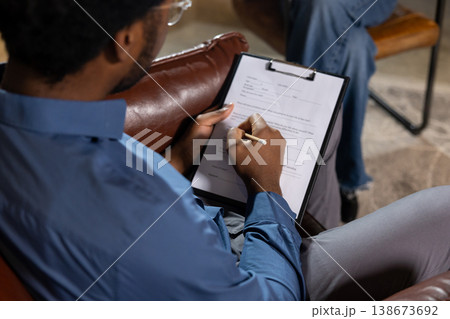 Man writing notes on clipboard Man writing notes on clipboard 138673692