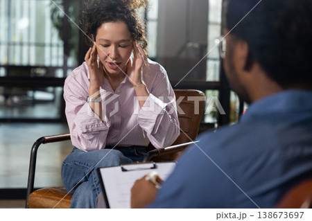 Woman client touching head feeling headache Woman client touching head feeling headache 138673697