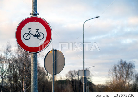 Bike restriction sign on a road beside trees with cloudy sky in the background Bike restriction sign on a road beside trees with cloudy sky in the background 138673830
