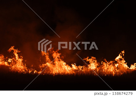Burning fire flames isolated on dark background with smoke, dramatic wildfire effect, high contrast fire texture for overlay and design use. 138674279
