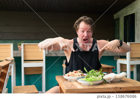 Shocked Man Pointing at Spicy Thai Food Som Tum Papaya Salad Expression Outdoor Restaurant Shocked Man Pointing at Spicy Thai Food Som Tum Papaya Salad Expression Outdoor Restaurant 138676086