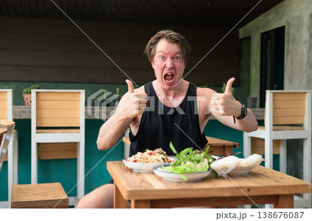 Shocked Man Giving Thumbs Up with Spicy Thai Food Som Tum Papaya Salad Expression Restaurant Shocked Man Giving Thumbs Up with Spicy Thai Food Som Tum Papaya Salad Expression Restaurant 138676087