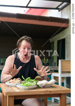 Shocked Man Reacting to Spicy Thai Food Som Tum Papaya Salad Vertical Portrait Copy Space 138676094