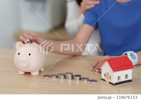 Child saving money with piggy bank and toy house Child saving money with piggy bank and toy house 138676153