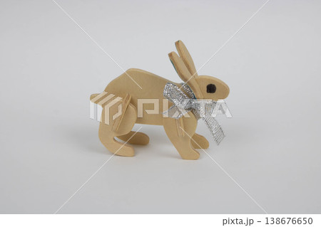 A brown wooden hare with a bow on a white table. A brown wooden hare with a bow on a white table. 138676650