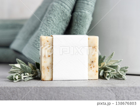 Beige solid soap bar with blank paper label mockup near with leaves and light green bath towel Beige solid soap bar with blank paper label mockup near with leaves and light green bath towel 138676803