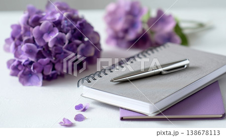 白背景のデスクに開いたノートとペン　紫陽花 138678113