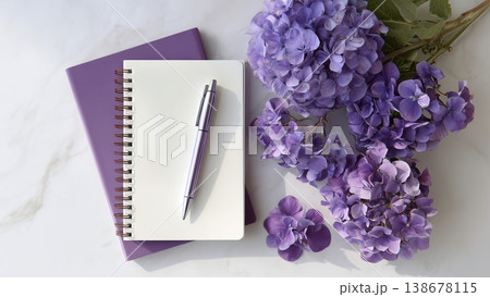 白背景のデスクに開いたノートとペン　紫陽花 138678115