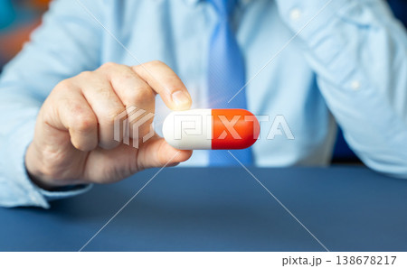 Businessman holding a medical capsule in hand Businessman holding a medical capsule in hand 138678217