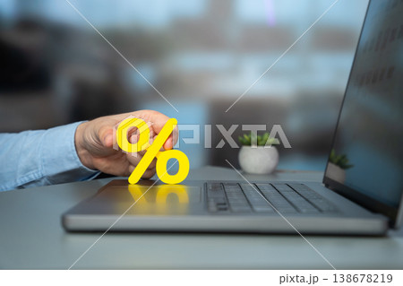 Man hand holding a percentage sign on a laptop keyboard. Man hand holding a percentage sign on a laptop keyboard. 138678219