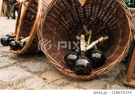 Dark bottles in wicker basket at festival market stall in Berlin Dark bottles in wicker basket at festival market stall in Berlin 138678354