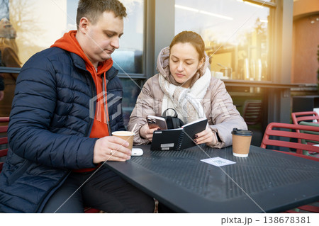 35 year old Caucasian man and 31 year woman sits at a table near a street cafe. 35 year old Caucasian man and 31 year woman sits at a table near a street cafe. 138678381