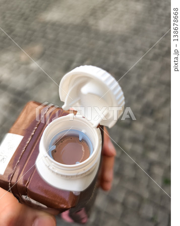Person holding chocolate milk carton with an open lid in prague 138678668