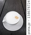 Creamy cappuccino served in a white cup on a dark wooden table coffee beverage concept. copy space 138678724