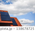 Solar panels installed on a modern rooftop against a backdrop of blue sky and fluffy clouds showcasing renewable energy solutions and sustainability concept 138678725