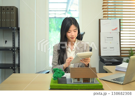 Architect calculating project budget at office desk, Professional architect reviewing construction costs. 138682308