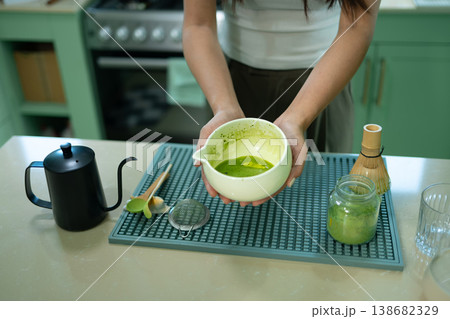 Cropped shot Woman holding bowl of freshly whisked matcha tea 138682329